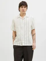 Camisa de manga corta con cuello resort y cierre de botones. Confeccionada en tejido dobby con mezcla de algodón y lino.