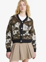 Cardigan de punto con diseño abstracto en tonos marrones, negros y blancos. Presenta cuello en V, cierre frontal con botones y terminaciones acanaladas en puños y ruedo.