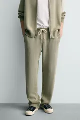 Pantalón relaxed fit tejido en hilatura de algodón con estructura, color verde militar. Presenta cintura elástica ajustable con cordón en contraste, bolsillos de vivo frontales y detalle de bolsillo trasero.