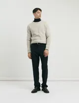 Sweater de punto en tono beige jaspeado, con cuello redondo y mangas largas, de corte clásico.