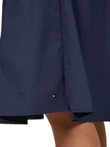 Falda midi azul marino de corte evasé, con botones frontales a lo largo de toda la prenda y logo de la marca bordado en el ruedo.