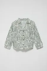 Camisa estampada de lino y viscosa en color crudo con diseño geométrico en verde jade, cuello camisero, cierre frontal con botones de madera y bolsillos appliqued en el pecho.