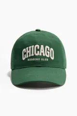 Gorra de sarga verde con efecto lavado y bordado delantero con el texto "Chicago Running Club" en color blanco.