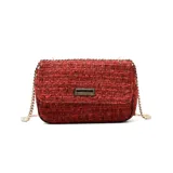 Cartera de hombro tipo sobre confeccionada en tejido de tweed rojo con textura, cuenta con una solapa frontal con placa metálica decorativa y correa de cadena dorada.