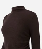 Vestido midi de punto color marrón chocolate, con manga larga, cuello alto sutil y detalle de fruncido lateral que ajusta la silueta. Diseño minimalista de corte recto.