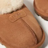 Pantuflas Ugg modelo Coquette color marrón con interior de piel de oveja color crema.