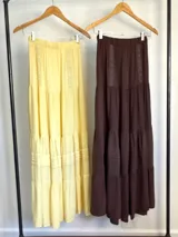 Falda larga marrón de estilo campesina, confeccionada en lino rayón liviano, con corte en capas y detalles de costuras verticales.