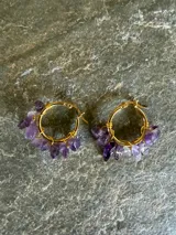 Aros de tipo argolla dorados decorados con pequeñas piedras naturales colgantes en tonos multicolores.
