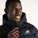 Campera puffer New Balance modelo Boston, color negro, con capucha, cierre frontal completo y bolsillos laterales. Presenta el logo de la marca bordado en blanco en el pecho.