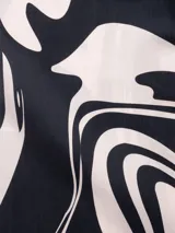 Camisa de manga corta con cuello tipo camp y estampado abstracto en tonos beige y negro.