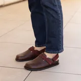 Zuecos de cuero marrón con tira de ajuste de velcro color borgoña.