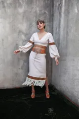 Pollera color crema, de corte recto, con detalle de cuero calado y flecos en el ruedo.