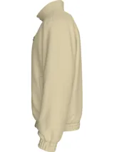 Campera de nailon color beige con cierre frontal de cremallera, cuello alto de canalé, puños y bajo elásticos. Presenta el logo de Calvin Klein bordado en el pecho y un parche con el logo en la manga izquierda.