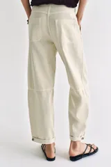 Pantalón de tiro bajo estilo chino, color blanco, con bolsillos delanteros, bolsillos de plastrón en la espalda y bajo acabado con vuelta. Cierre frontal con cremallera y botón.