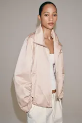 Chaqueta bomber de Zara Woman Collection color rosado, con cuello subido, cierre frontal con cremallera, mangas largas y bajo abullonado con elástico.