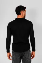 Remera de manga larga color negro, confeccionada en algodón, con cuello redondo y cierre frontal parcial con botones.