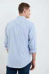 Camisa celeste y blanca a rayas verticales, de manga larga con puños abotonados y cuello clásico.