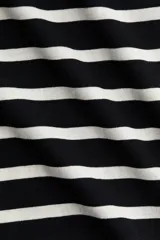 Remera de corte recto confeccionada en punto suave de algodón, con cuello redondo ribeteado y hombros ligeramente caídos.