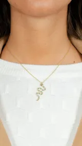 Cadena dorada con dije de serpiente con incrustaciones de circonitas verdes y transparentes.