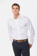 Camisa blanca lisa de vestir con cuello clásico, manga larga y corte slim fit. Confeccionada con 60% algodón, 37% poliéster y 3% spandex. Cuenta con pinzas en la espalda en talles XL al XXX, botones personalizados y logo bordado en el pecho.