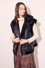 Chaleco negro de cuero sintético con cuello de piel sintética y cierre frontal con cremallera.