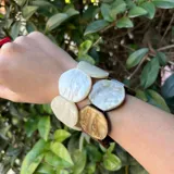 Pulsera elástica hecha de resina con círculos de color verde oliva y verde agua.