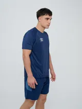 Remera deportiva Umbro modelo Axis, de manga corta, color gris claro con textura perforada transpirable y logo negro de la marca en el pecho.