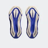 Championes de running Asics modelo Novablast 5, color gris con detalles en blanco, naranja y azul. Presentan una mediasuela con tecnología FF BLAST MAX para mayor amortiguación y retorno de energía, y una capellada de malla jacquard transpirable.