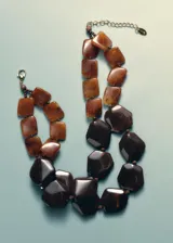 Collar de abalorios acrílicos en tonos marrones y carey con diseño de múltiples piezas geométricas y cierre de cadena con mosquetón.