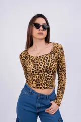 Remera corta color marrón con estampado animal print de leopardo, escote asimétrico y manga larga.