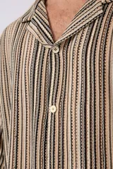 Camisa de manga corta con cuello abierto, confeccionada en tejido ligero con un patrón de rayas verticales finas en tonos beige, negro y rosado.