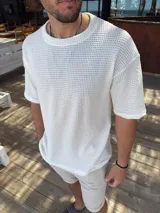 Remera de tejido de punto con textura tipo waffle, color blanco, de corte oversize y manga corta.