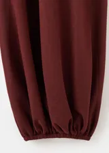 Pantalón balloon de tiro medio, color bordó, con cintura ajustable elastizada y bajos con goma elástica.