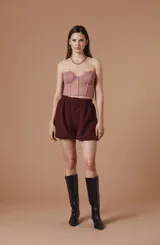 Top tipo corset de encaje negro con escote strapless y copas estructuradas. Presenta detalles de encaje con bordes festoneados y paneles transparentes en el torso.