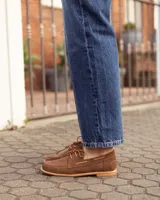 Mocasines estilo náutico de cuero color marrón, con cordones y costuras pespunteadas en el empeine.