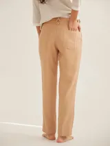 Pantalón de corte cigarette con cintura de tiro medio, cierre frontal con botón y bolsillos laterales. Presenta un diseño clásico de líneas limpias y dobladillo con costura visible.