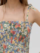 Top crop de tela fruncida con estampado floral multicolor, con breteles finos ajustables mediante lazos.