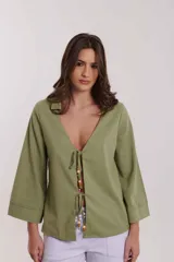 Camisa beige de lino con mangas anchas y lazos con cuentas de madera para atar en el frente.