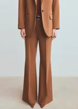 Pantalón de vestir marrón, de corte flared, con tiro medio y bolsillos laterales.