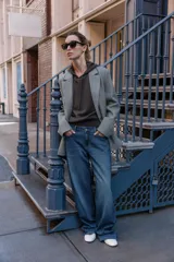 Blazer de corte recto y diseño minimalista, confeccionado en tejido de paño suave color beige. Presenta cuello con solapas clásicas, cierre frontal con un solo botón y dos bolsillos delanteros con solapa.