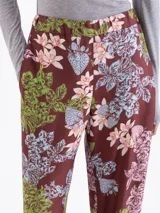 Pantalón de corte recto y holgado, con estampado floral y de fresas sobre fondo color marrón. Presenta cintura elástica y diseño fluido.