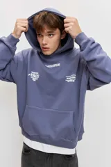 Canguro de friza color azul acero, con capucha, bolsillo tipo canguro y estampado gráfico en el pecho con texto en blanco.