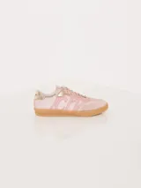 Zapatilla acordonada rosa de cuero con logo CH en los laterales y aplique metálico en el empeine.