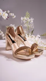 Sandalias negras de cuero sintético, con plataforma y tacón cuadrado. Presentan una tira ancha con strass sobre los dedos y pulsera con hebilla al tobillo.