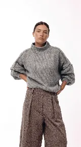 Sweater de punto grueso con cuello alto, diseño de hombros caídos y mangas amplias con puños acanalados.