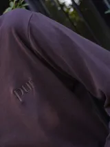 Remera de manga larga color negro, con bordado minimalista en el pecho que dice 'pur'.