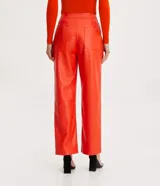Pantalón recto de cuero sintético color naranja, con cierre frontal con botón y cremallera.