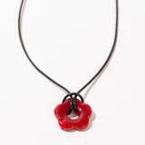 Collar con colgante de flor roja y cordón negro con cadena de alargue plateada.