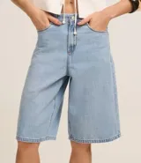 Bermuda tipo jorts de tiro alto confeccionada en denim de algodón, con diseño de cinco bolsillos, trabillas para cinturón y cierre frontal con botón y cremallera.