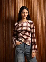 Blusa de terciopelo con estampado a cuadros, corte asimétrico y mangas largas acampanadas.